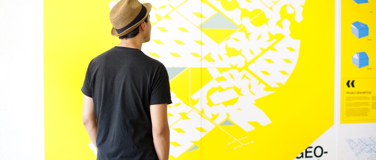 student wearing a hat looking at graphic design on a wall at UCLA